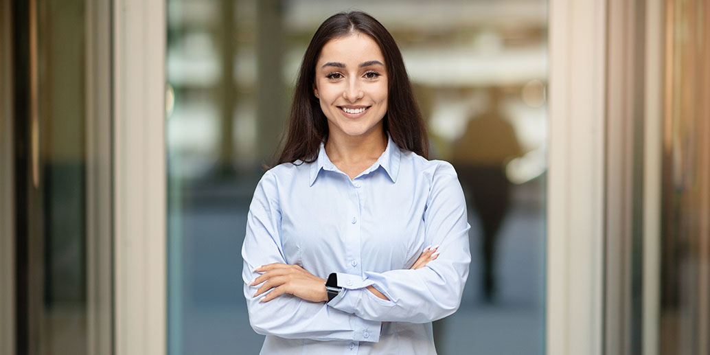 Femme brune consultante en développement durable en chemise bleu, sourit à la camera